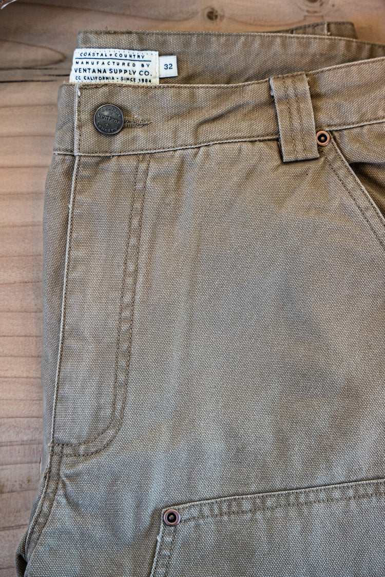 Close-up of the Draftsman Pant in salt washed Tobacco, featuring a custom Ventana Supply Co. branded button, copper rivet reinforcements, and a woven manufacturing label.