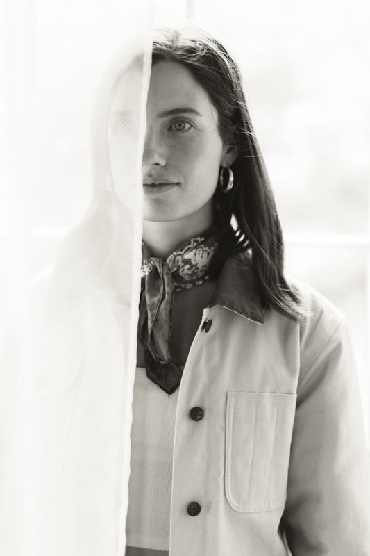 Artistic portrait of a woman wearing the canvas utility chore jacket, highlighting the structured fit, metal buttons, and detailed patch pocket.