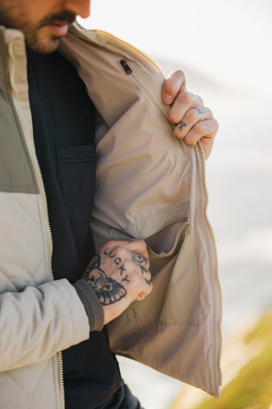 Interior view of the men's Cruzer jacket showcasing a secure zippered chest pocket and a large internal drop pocket for functional storage.