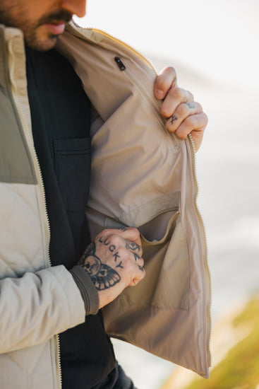 Interior view of the men's Cruzer jacket showcasing a secure zippered chest pocket and a large internal drop pocket for functional storage.