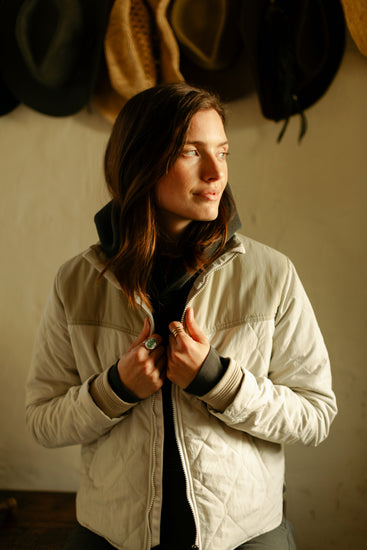 Close-up of the women's Cruiser Jacket in cream, featuring diamond-quilted fabric, a tan yoke, and heavy-duty ribbed knit cuffs for wind protection.