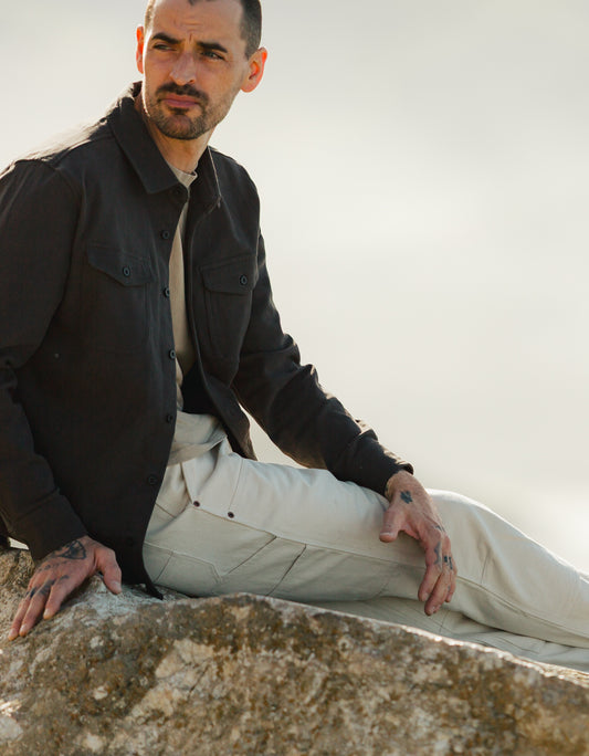 Men’s Draftsman Pant in soft washed cream showcasing side utility pockets, paired with the South Coast Shirt in vintage coal for a rugged outdoor look.