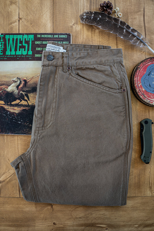 Flat-lay of the Tradesman Pant in salt washed Tobacco, featuring triple-needle reinforced seams, a custom VNTNA branded button, and 100% cotton canvas utility construction.