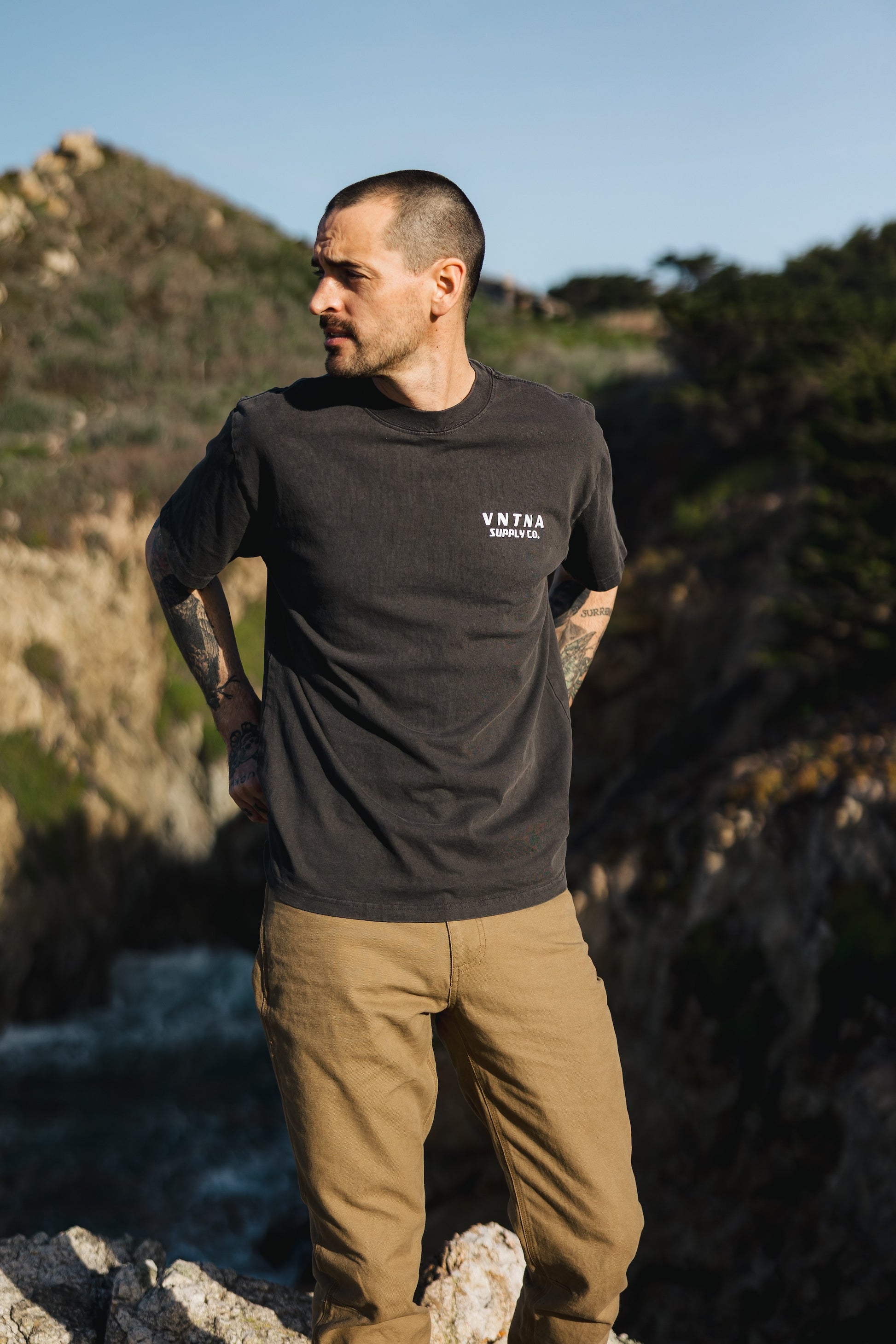 Men’s Tradesman Pant in salt washed Tobacco, featuring a durable 100% cotton canvas build, styled with a charcoal VNTNA Supply Co. graphic tee.